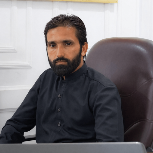 Hafiz Iqrar Ahmed sitting on a office chair